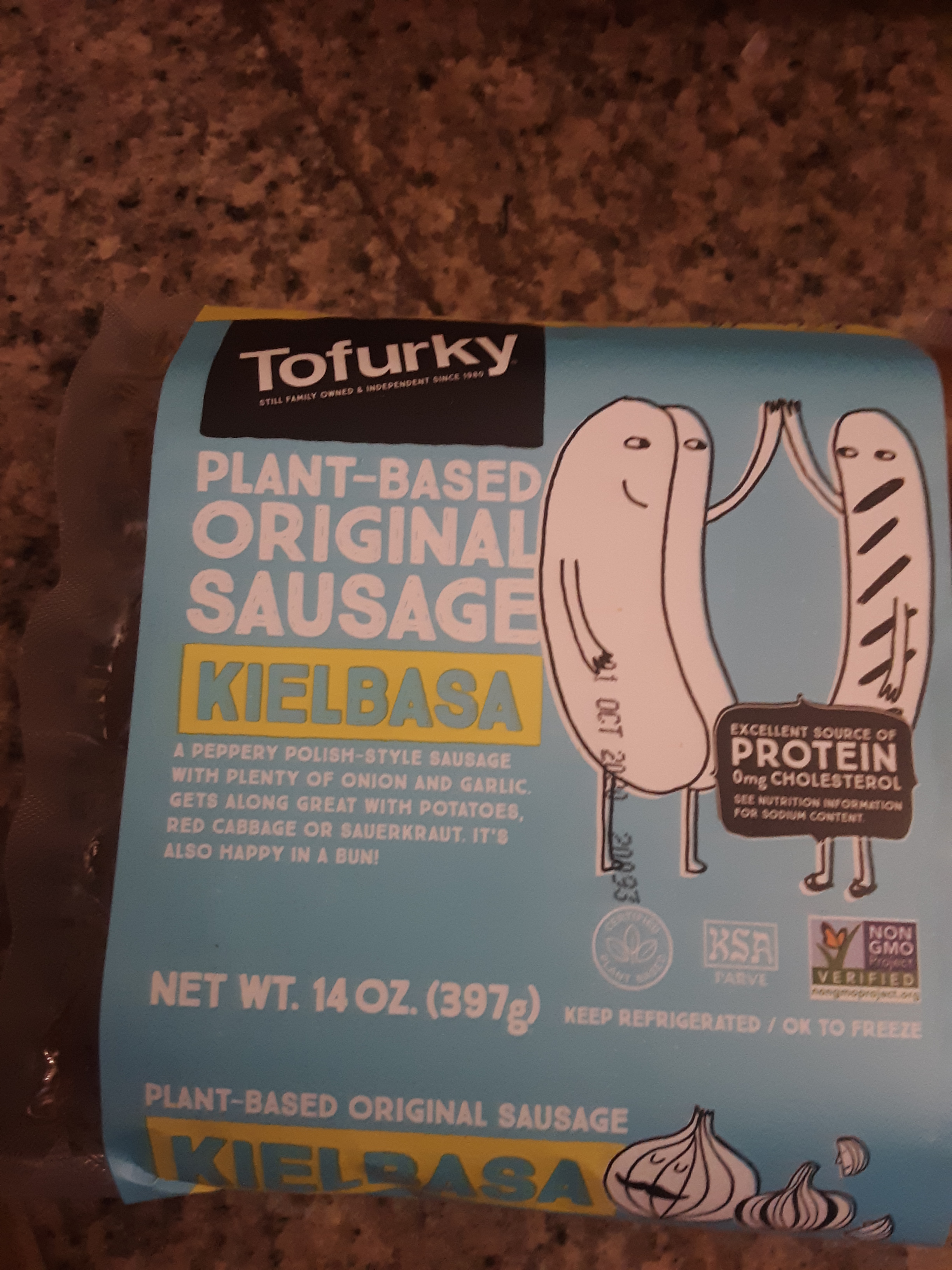 Living well in the 21st century - Limassol, Cyprus - a picture of vegan sausage - tofurky - plant-based original sausage kielbasa - a peppery polish-style sausage with plenty of onion and garlic. Gets along great with potatoes, red cabbage or sauerkraut. It's also happy in a bun! The label is blue with a picture of white buns giving each other a high 5. There is a note that says, "excellent source of protein 0mg cholesterol - see nutrition information for sodium content. Net wt. 14 oz. (397g) keep refrigerated / ok to freeze 