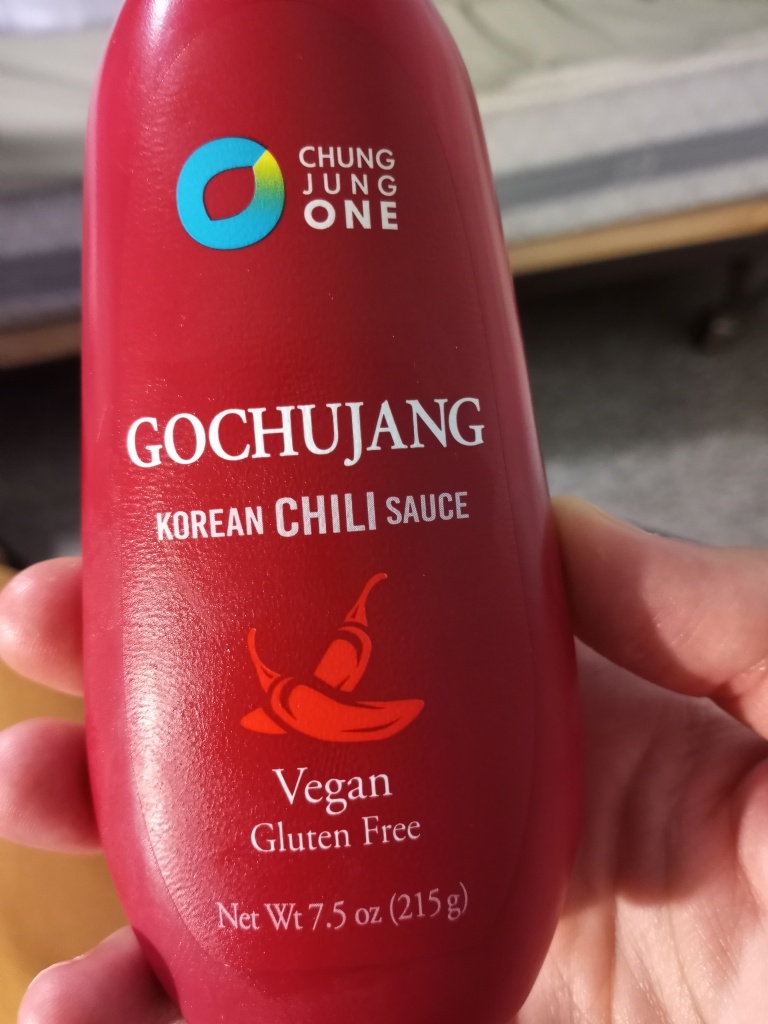Living well in the 21st century - Limassol, Cyprus - red plastic bottle that has the letters: Gochujang - korean chili sauce - vegan - gluten free - net wt 7.5 oz (215g).