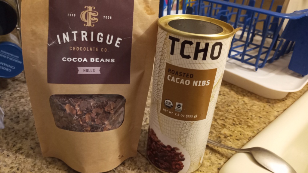 Living well in the 21st century - Limassol, Cyprus - a picture of a package that says, "intrigue chocolate co. - cocoa beans hulls- estb 2006. Tcho package that says, "Tcho roasted cacao nibs net wt 7.8 oz (222 g).
