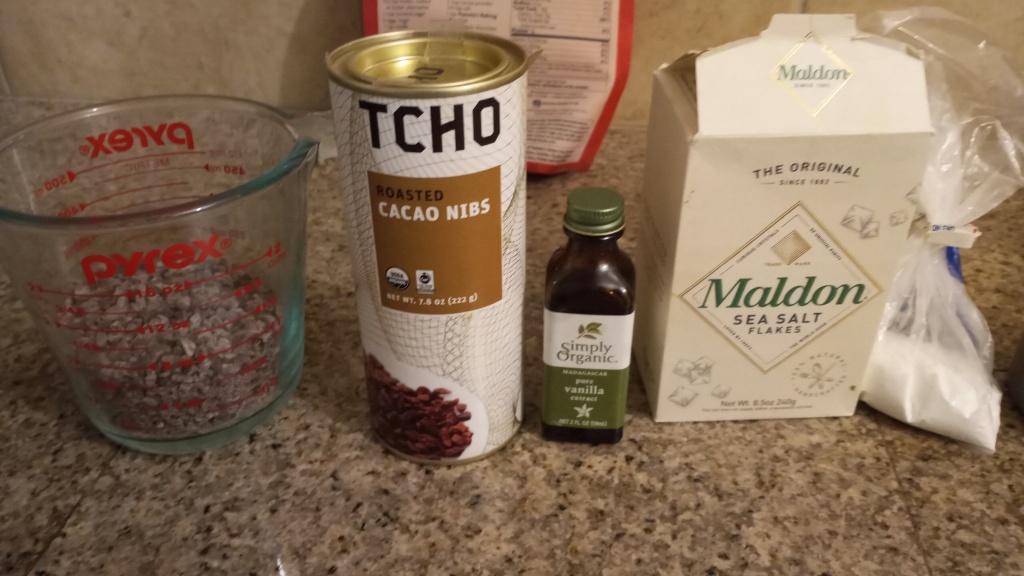Living well in the 21st century - Limassol, Cyprus - A picture of Tcho roasted cacao nibs container, a bottle of pure vanilla, a package of maldon sea salt flakes, and baking powder. 