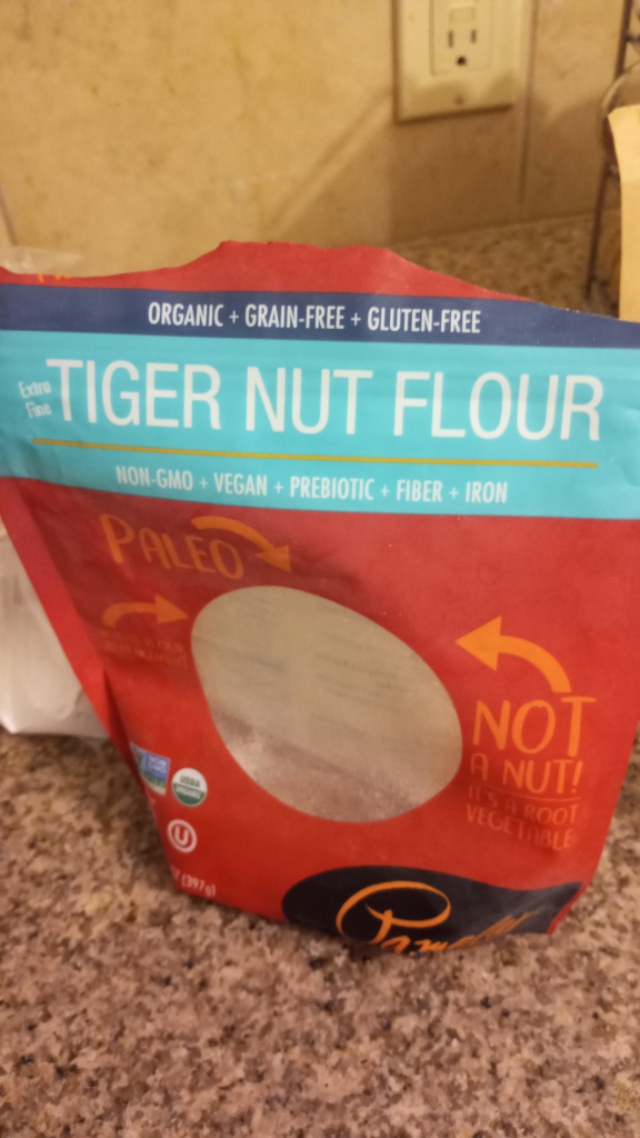 Living well in the 21st century - Limassol, Cyprus - a picture of package of tiger nut flour - extra fine - organic + grain-free + gluten-free - non-gmo + vegan + prebiotic + fiber + iron. Arrows towards the package that say, " paleo, not a nut! it is a root vegetable." 